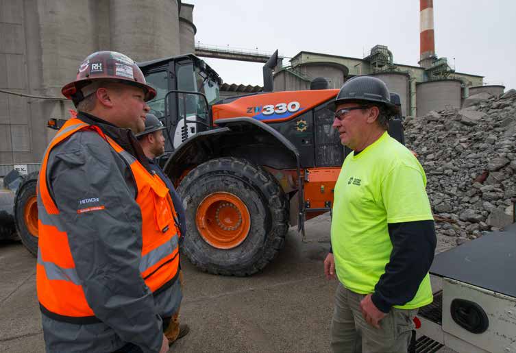 Greg DeHaan and Scott Cunningham discussing in front of a ZW330 on a job site